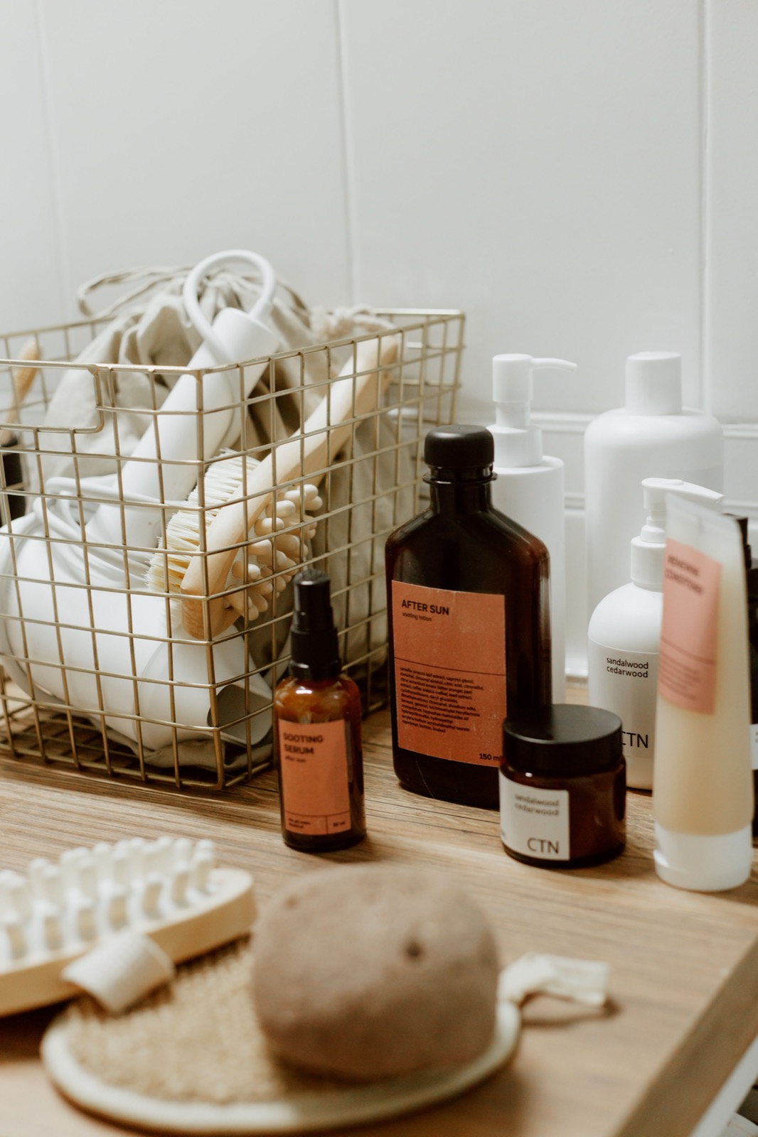 An assortment of skincare products laid out on a bed